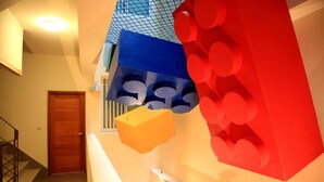 Una escalera con una puerta de madera al final, barandilla y un accesorio de iluminación con varias bombillas.