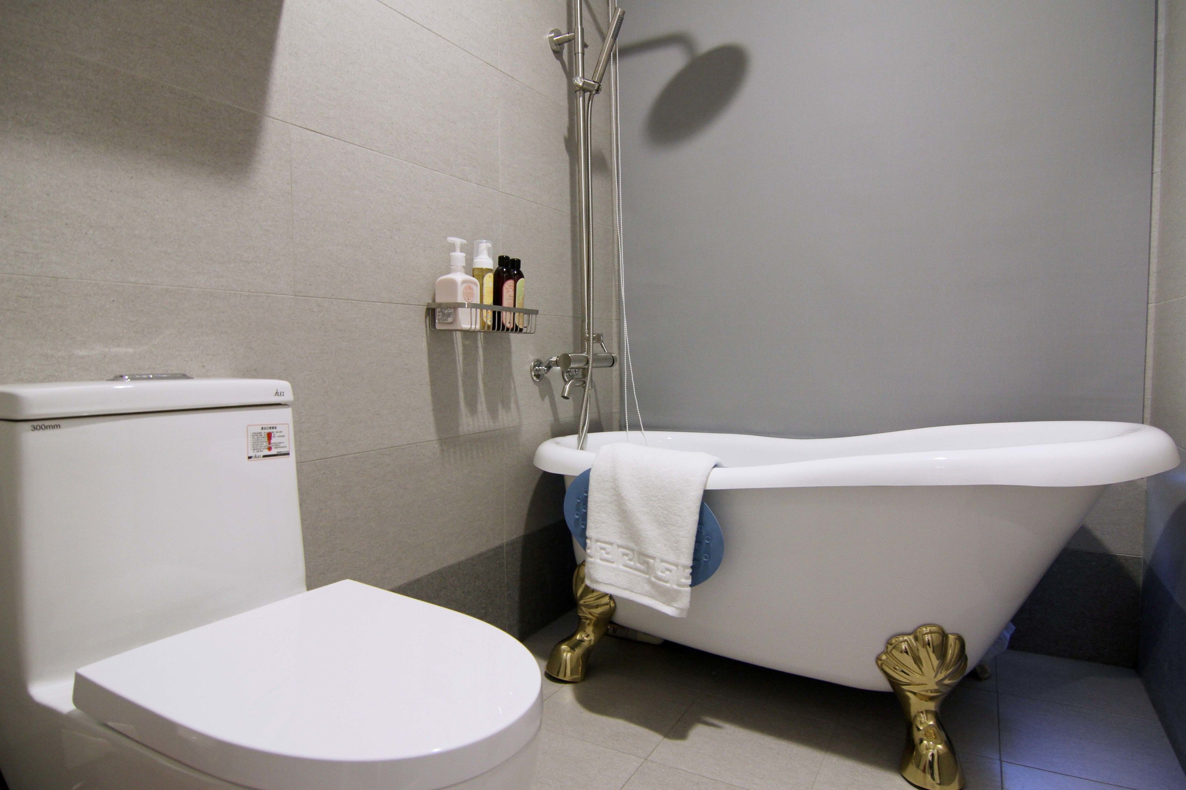 A bathroom with a toilet, a bathtub, and a shower.