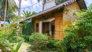 A wooden house with a tiled roof, surrounded by lush greenery and a stone pathway. - Dendi Resort Phu Quoc (Phu Quoc)