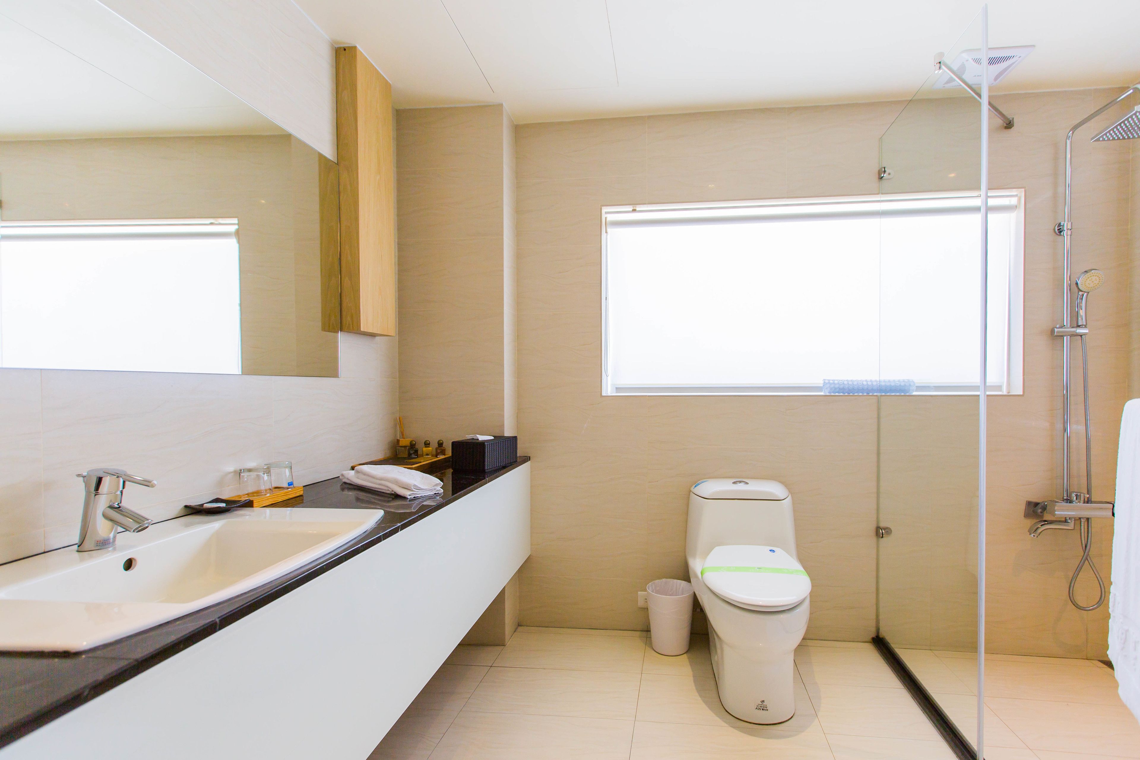 Un baño moderno con lavamanos, inodoro y ducha.