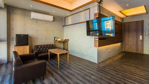 Una sala de estar moderna con televisor de pantalla plana, sofá de cuero y mesa de centro de madera.