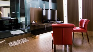 Un baño moderno con cabina de ducha de vidrio, un espejo grande y un mueble de tocador con lavabo y toallero.
