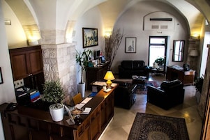 Um hall amplo com uma mesa de recepção, área de estar e um pilar de pedra.