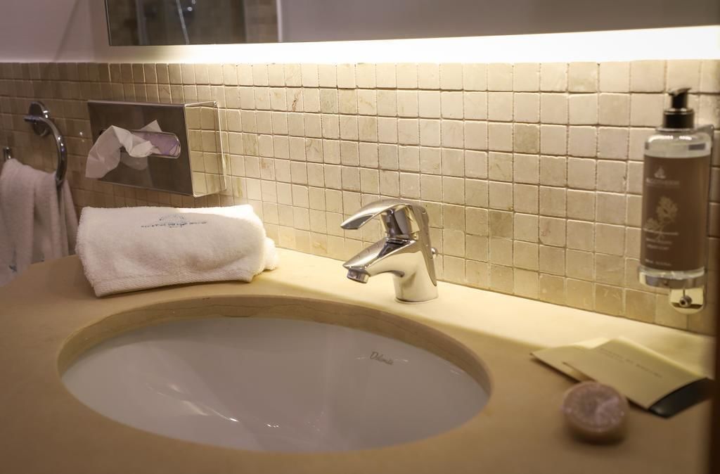 A bathroom sink with a mirror, a towel, and toiletries.