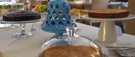 Une table où sont présentés divers desserts, notamment des gâteaux et des tartes, avec une lanterne bleue décorative placée au centre.