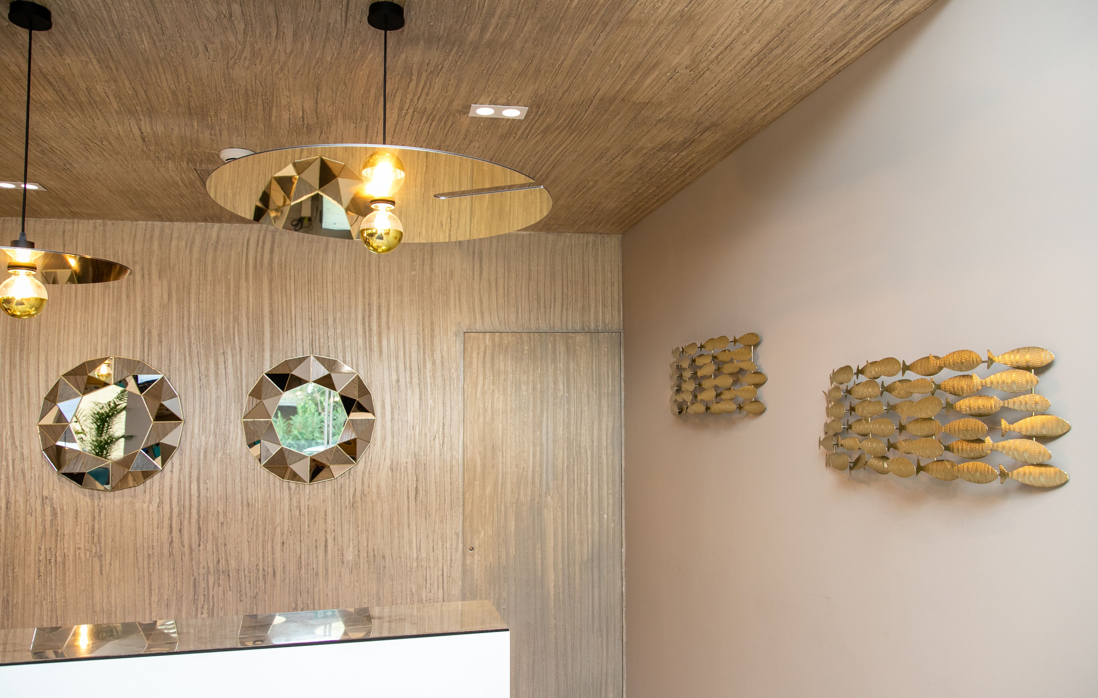 A modern interior with wooden panel walls, circular mirrors, and geometric wall art.