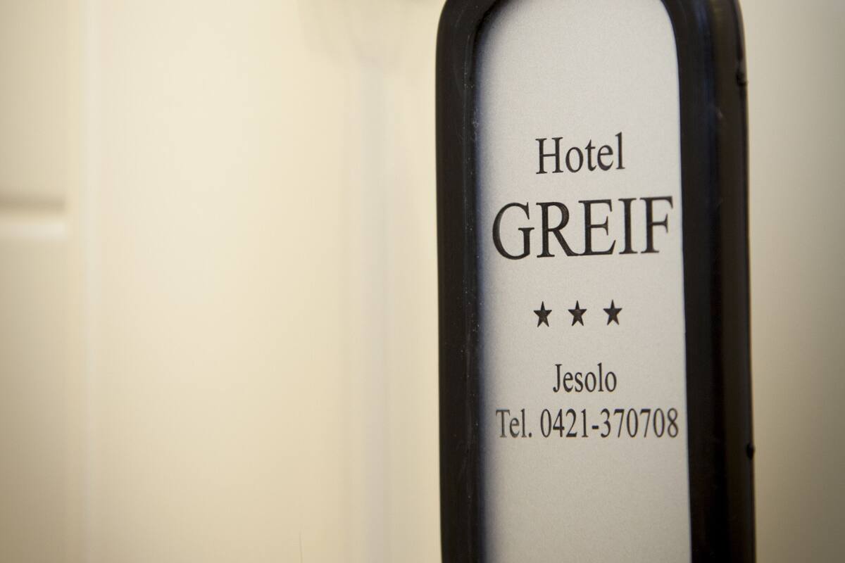 Un llavero de hotel con el nombre "Hotel Greif" e información de contacto.