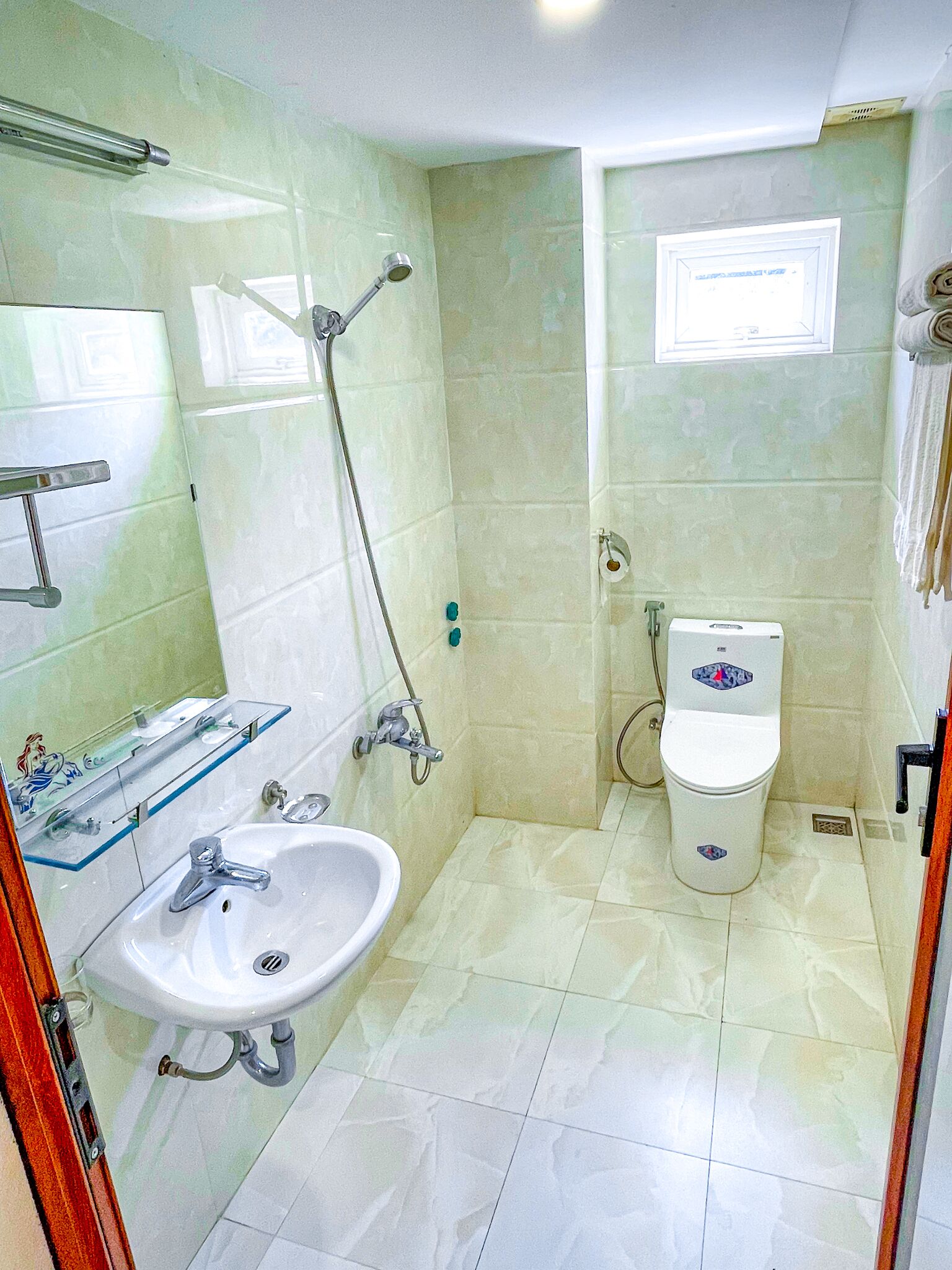 Un baño con lavabo, espejo e inodoro.