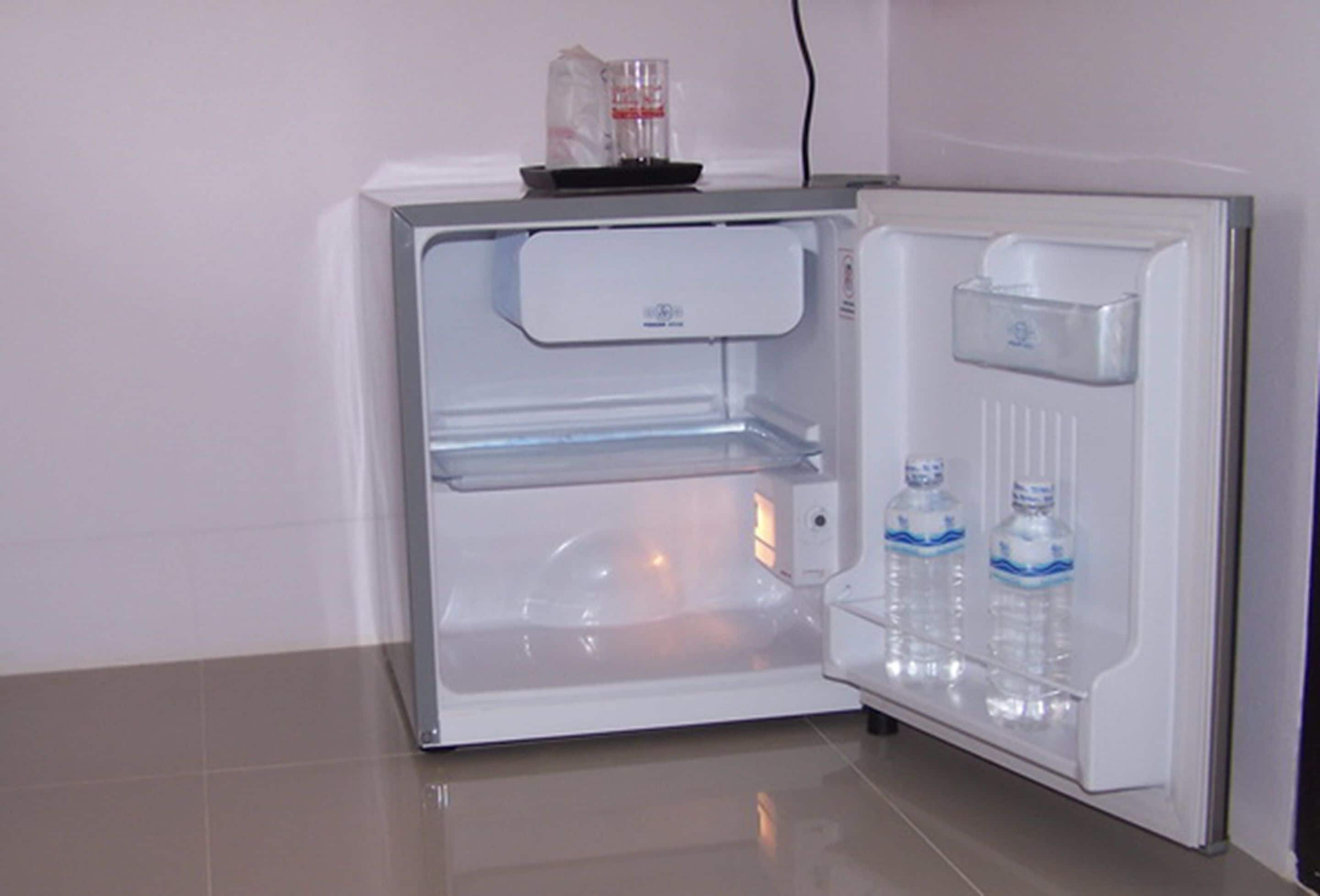 An open refrigerator with a water dispenser and a small shelf.