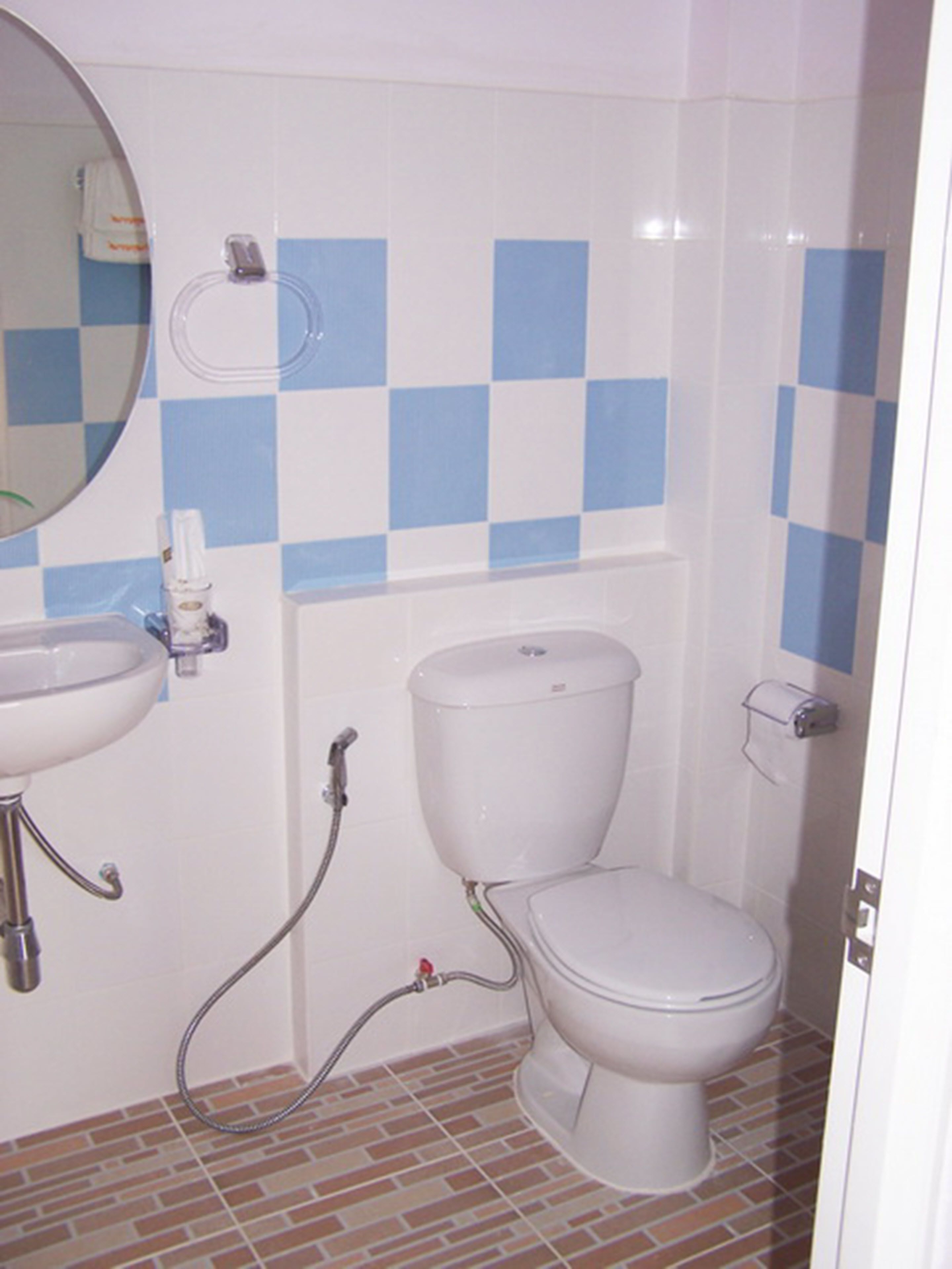 A bathroom with a white toilet, a sink, and a shower.