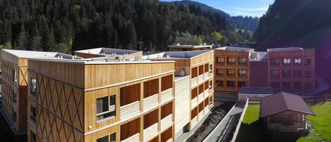 Situated in a valley, this building features a grid-like pattern of windows and balconies.