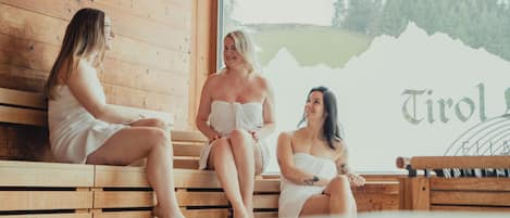 En stuga med träpanel på insidan, utrustad med bänkar och ett stort fönster.