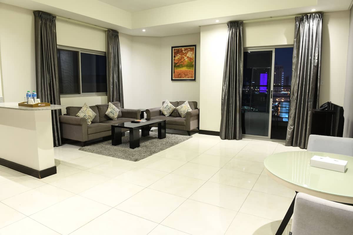 A modern living room with a sofa set, a coffee table, and a glass table with a box.