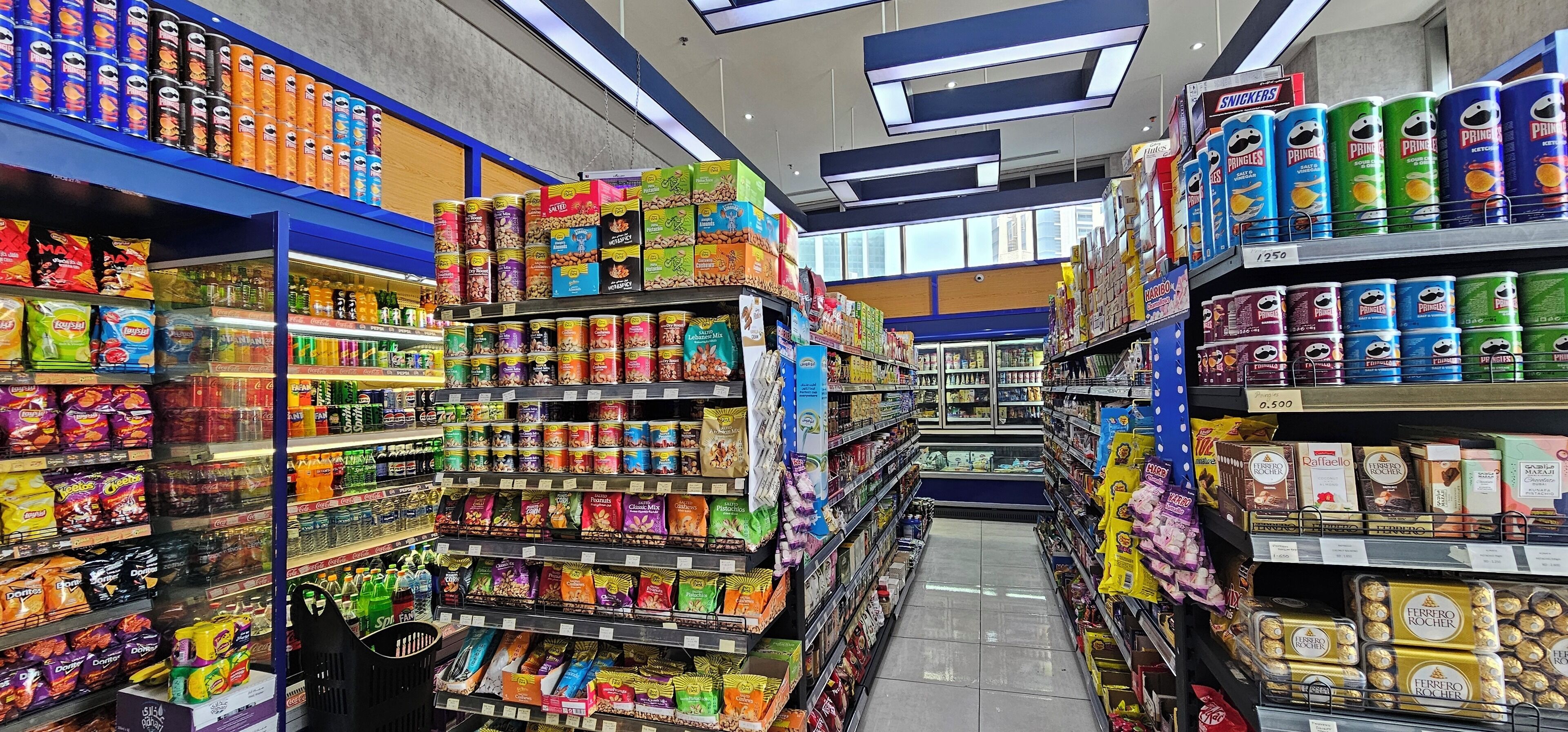 En butiksreol i et supermarked med forskellige snacks og fødevarer.