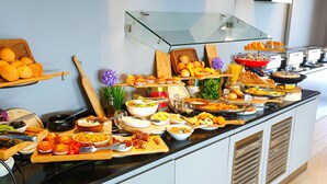 A buffet with various food items and utensils. - Loumage S Suites and Spa (Manama)