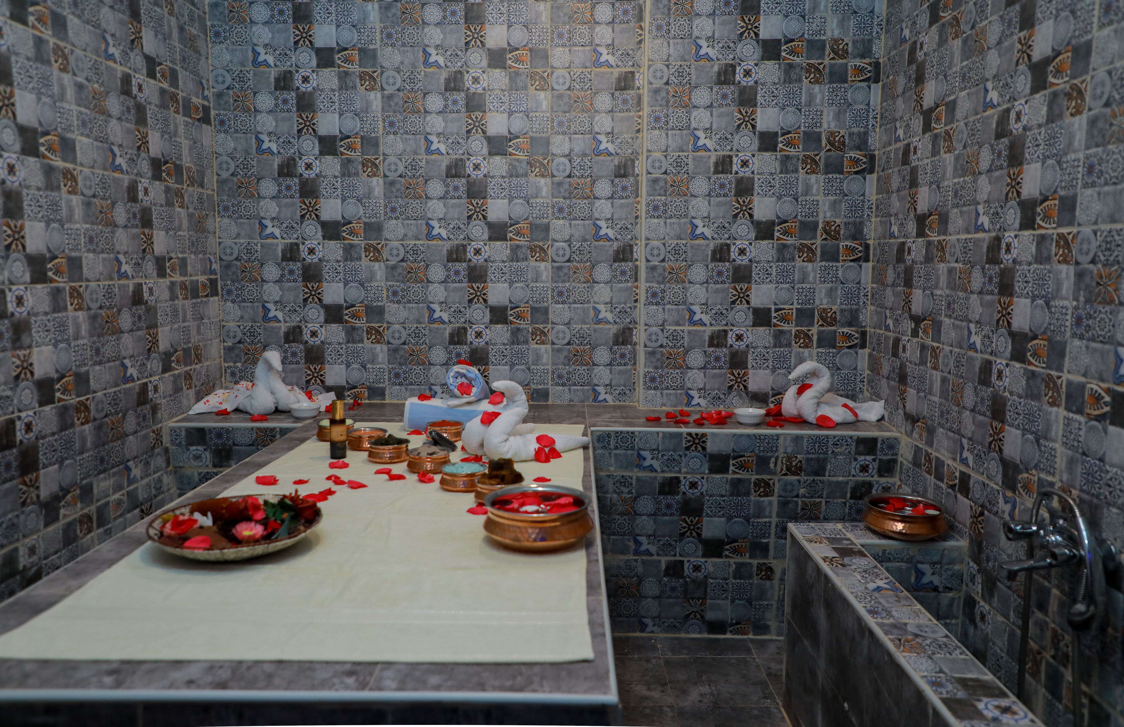Un baño con baldosas estampadas, una bañera, un lavamanos y un espejo.