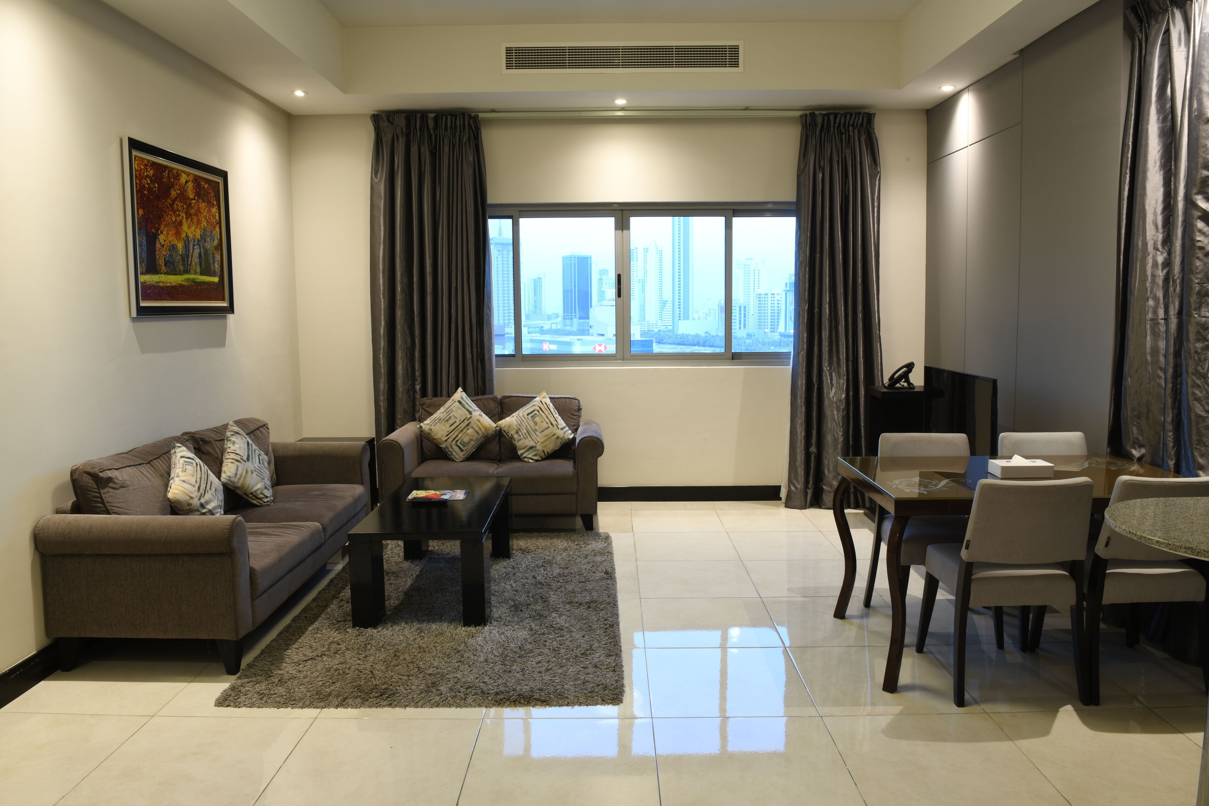 A modern living room with a sofa, coffee table, and dining area.