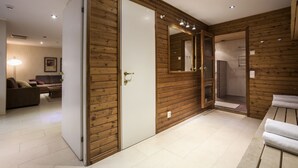 A modern bathroom with wooden paneling, a white door, and a mirror.