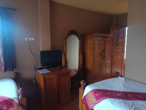 A room with a bed, a wooden wardrobe, a television, and a mirror. - Tai Asean House (Udon Thani)