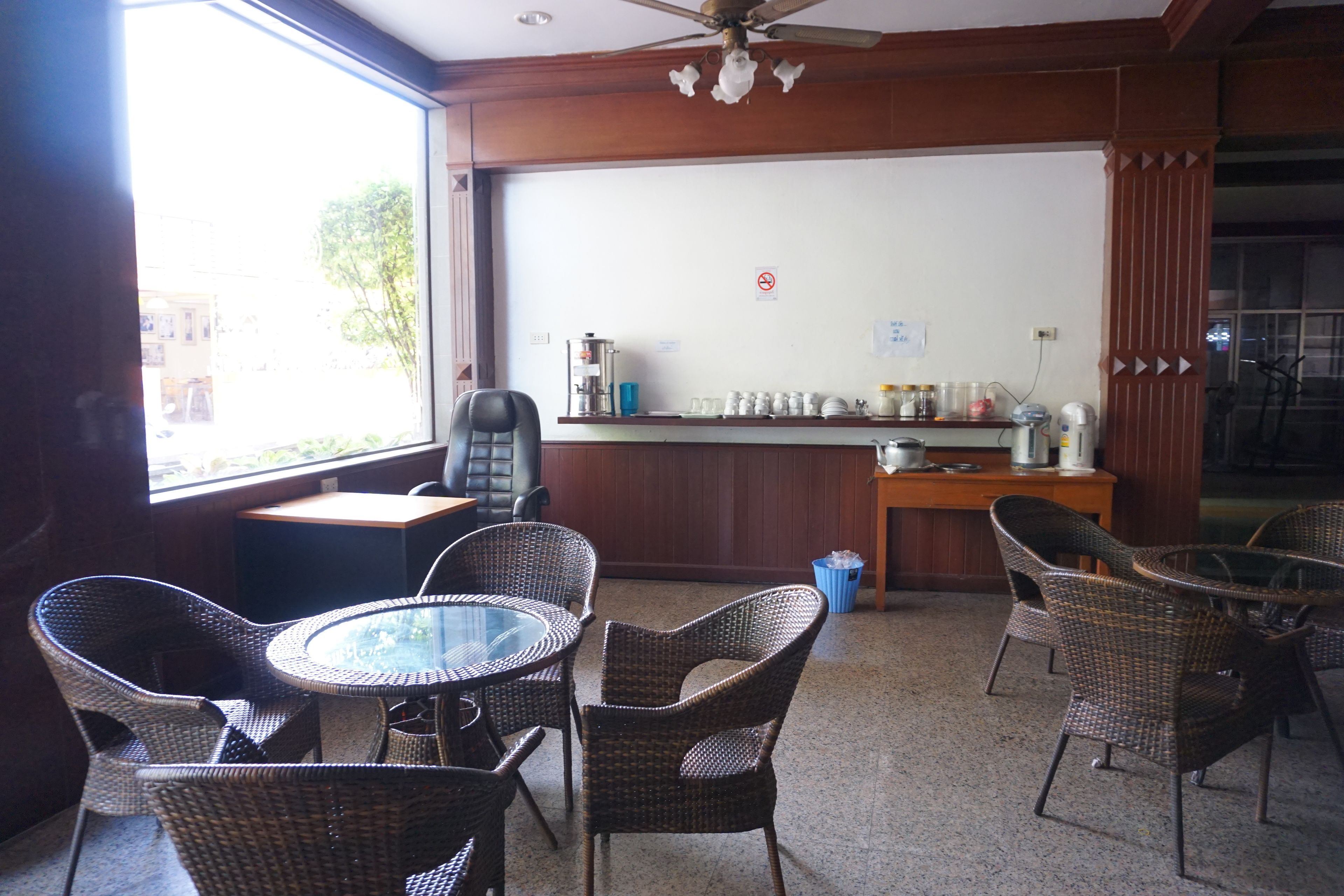 Una habitación con muebles de mimbre, una pizarra y una zona de bar con diversos objetos.