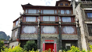 Un edificio tradicional de varios pisos con una puerta roja y elaborados marcos de madera.