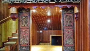A wooden staircase leading to a room with a sloped ceiling and decorative panels.