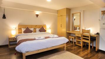 Une chambre à coucher avec un lit en bois, des tables de chevet avec des lampes, un bureau en bois et un miroir.