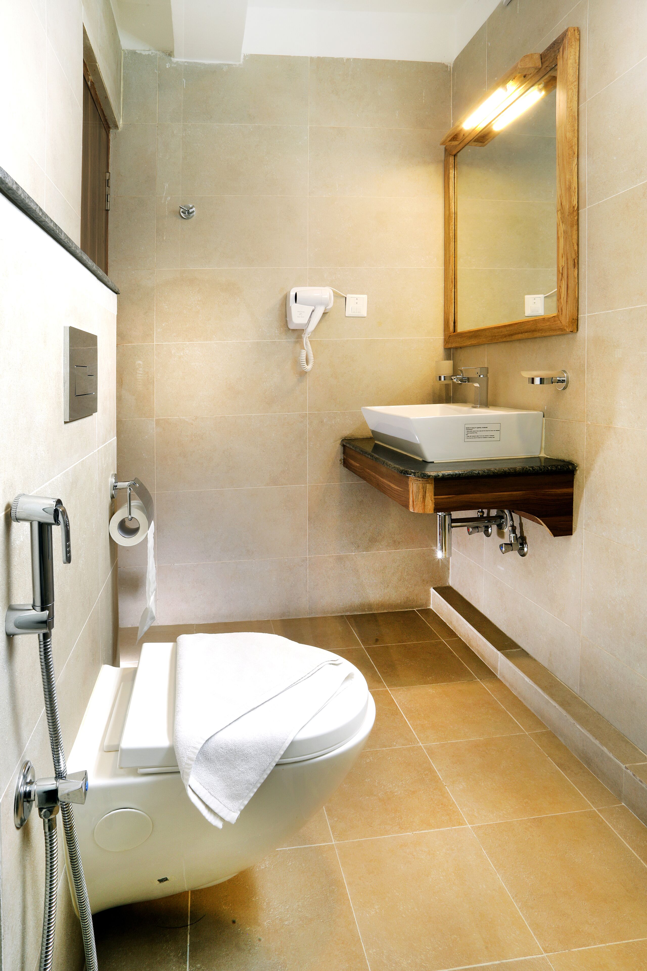 A bathroom with a toilet, sink, and mirror.