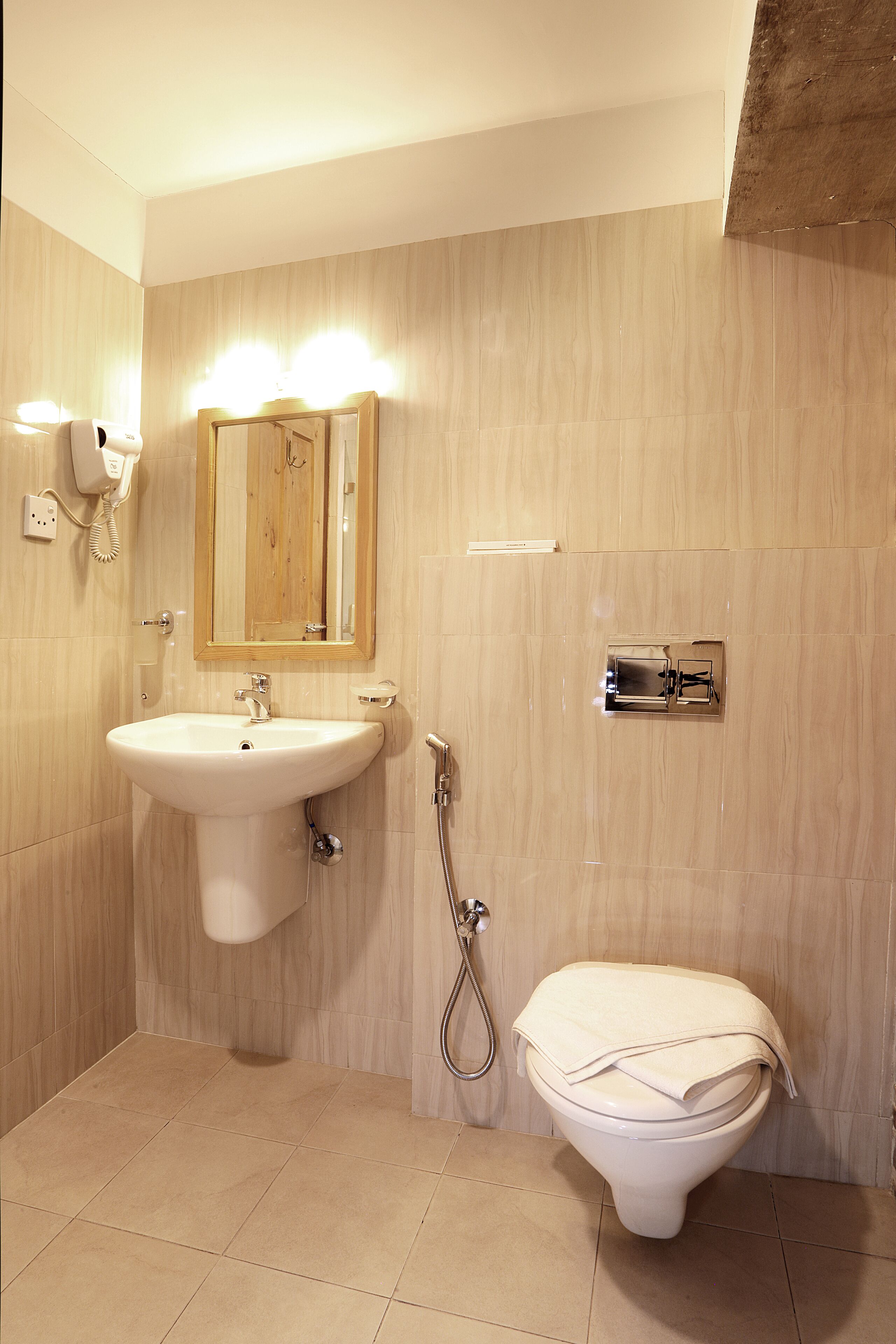 Een badkamer met een wastafel, spiegel en toilet.