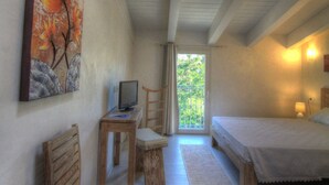 A bedroom with a skylight, a desk with a computer, a chair, a bed, and a painting on the wall. - La Casa di Pier (Olbia)