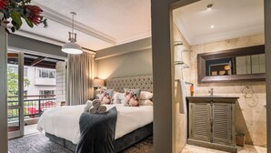 A hotel room with a large bed, a balcony, a bathroom with a mirror, and a shower area. - Avemore Jan Cats No 2 (Stellenbosch)