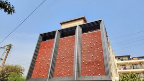 Um edifício moderno com fachada singular, destacando uma grade de aberturas quadradas.