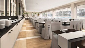 A modern restaurant with a long counter, multiple tables, and chairs.