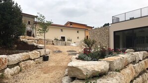 A courtyard with stone walls, a pathway, and a building with a tiled roof. - Sotto Le Stelle (Picinisco)