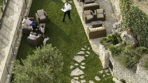 An outdoor patio area with stone walls, a grassy lawn, and outdoor furniture. - Sotto Le Stelle (Picinisco)