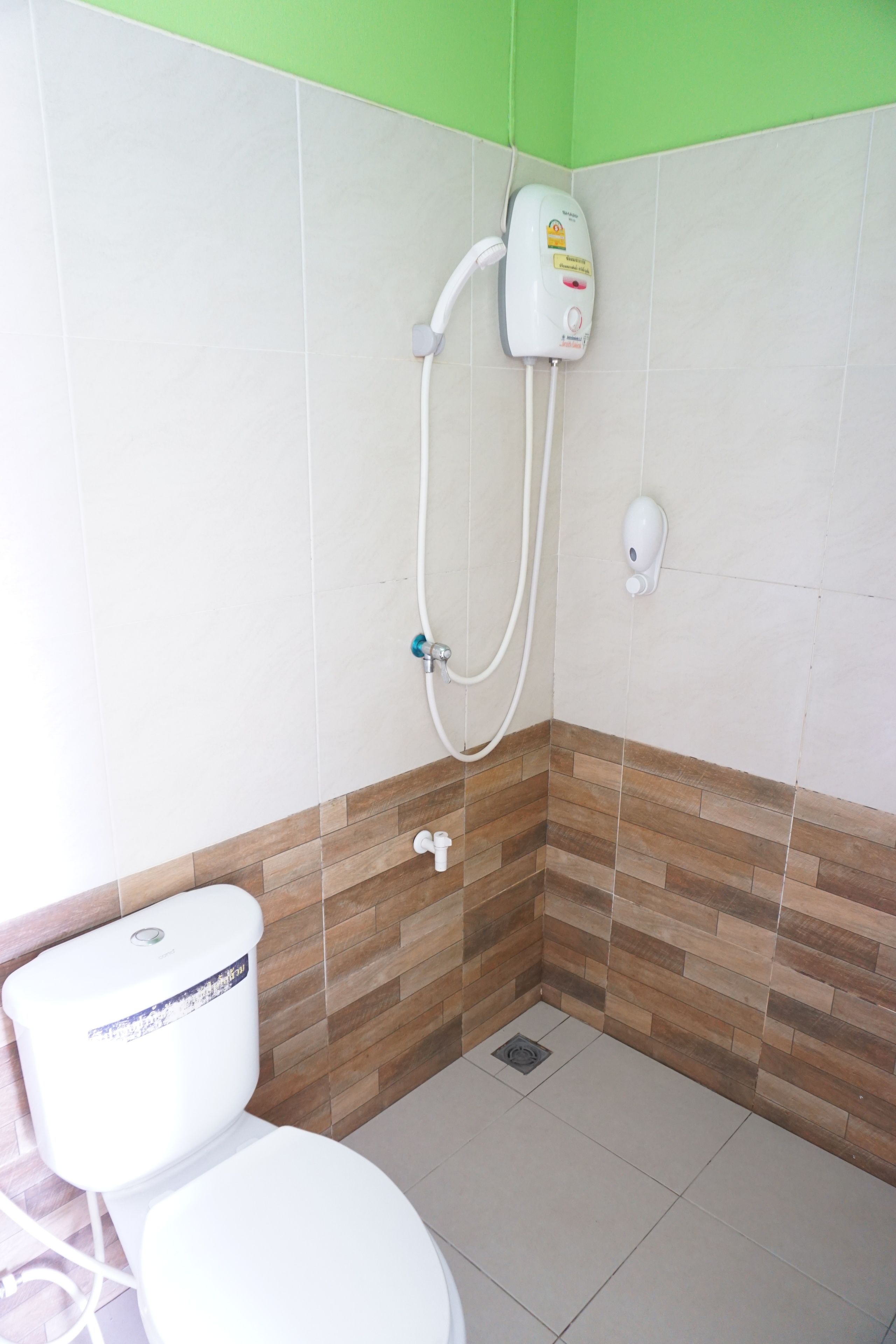 Un baño con inodoro, ducha y secamanos.