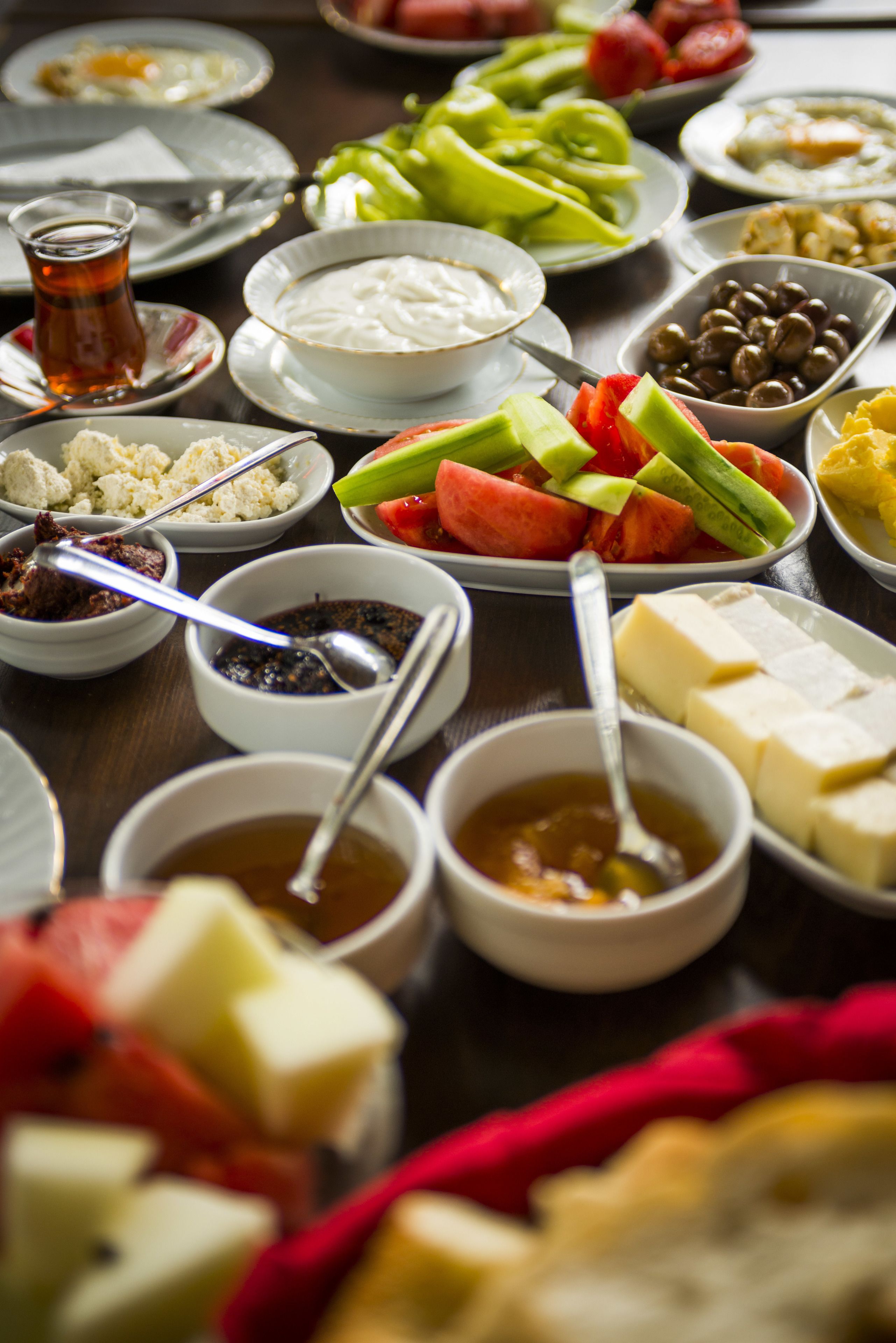 A table with various dishes and bowls of food, including fruits, vegetables, and dips.