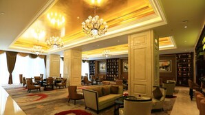 A spacious lobby with a large sofa, multiple armchairs, a chandelier, and a carpeted floor. - Lanxi International Hotel  (Xi'an)