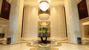 A grand lobby with high ceilings, large columns, and a central round table with vases. - Lanxi International Hotel  (Xi'an)