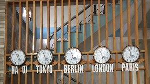 Una parete con orologi che mostrano l'ora di diverse città: Hanoi, Tokyo, Berlino, Londra, Parigi.