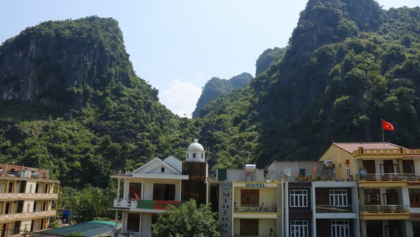 Un hotel con un cartello che indica la zona Midtown, circondato da dolci colline verdi e una montagna imponente sullo sfondo.