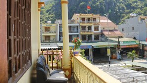 Un hotel con un balcone, vista sugli edifici circostanti e una bandiera su un edificio sullo sfondo.