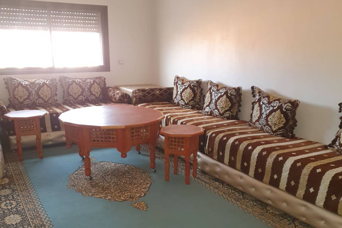 Ein Wohnzimmer mit einer Sofagarnitur, einem runden Couchtisch und zwei kleinen Beistelltischen.
