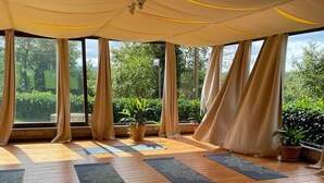 A yoga studio with wooden floors, yoga mats, and large windows with curtains. - Castello di Santa Cristina (Grotte di Castro)