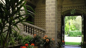 A stone staircase leading to a garden area with potted plants and flowers. - Castello di Santa Cristina (Grotte di Castro)
