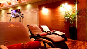 A spa room with massage chairs, a television, and a potted plant. - Hotel Iskierka Business & Spa (Mielec)