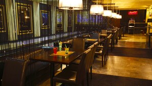 A restaurant with a long counter, multiple tables, and chairs. - Hotel Iskierka Business & Spa (Mielec)