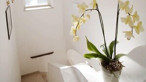 A staircase leading to a landing with a potted orchid on a white table. - B&B Il Sogno (Anacapri)