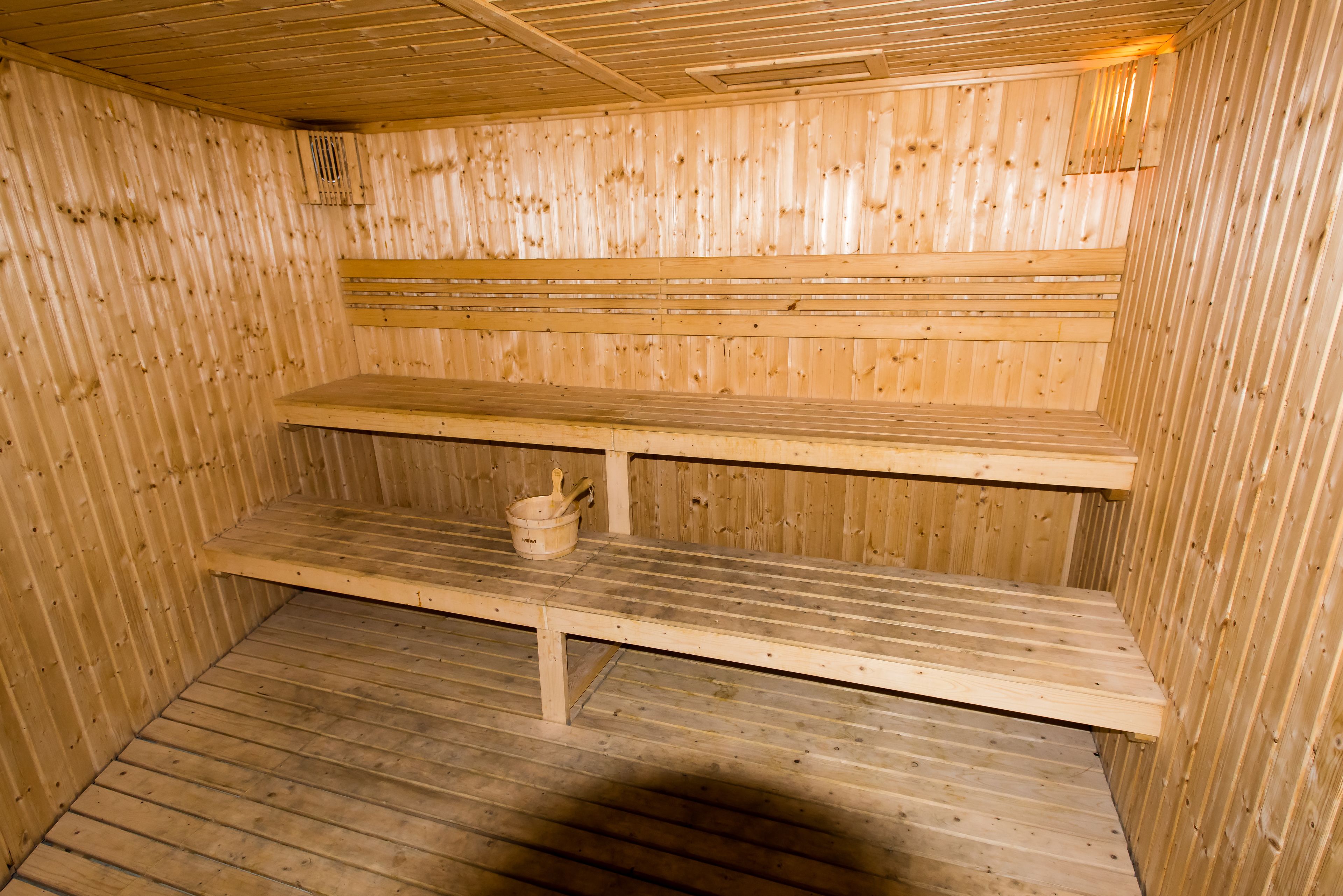 Un sauna avec des bancs en bois et un plancher en bois.