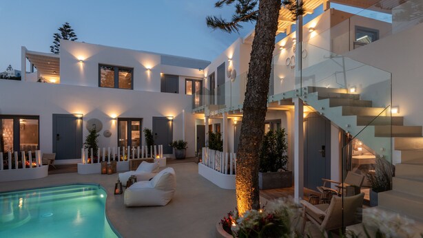 A modern house with a swimming pool, outdoor seating, and a staircase. - Oniro Suites (Mykonos)